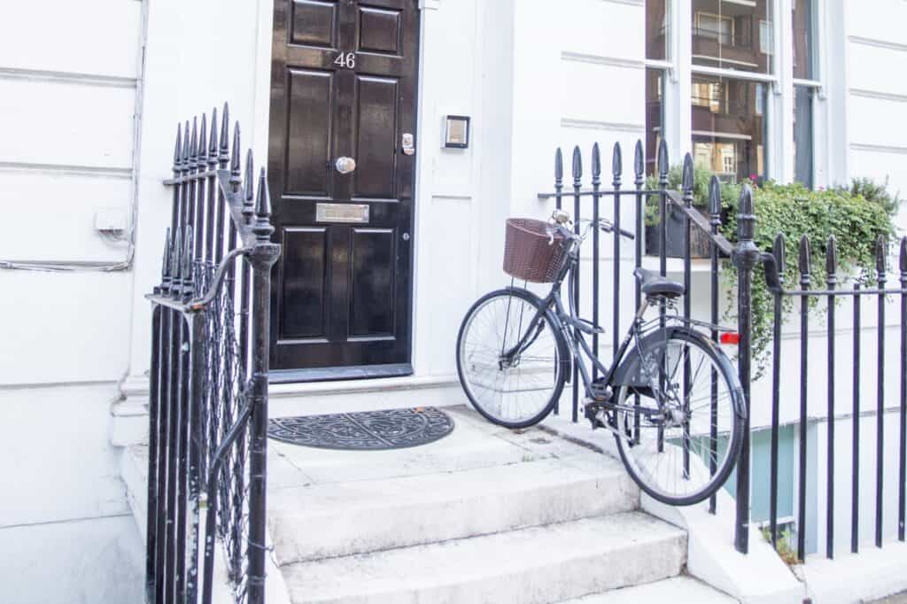 A British house with a bicycle on the front steps.