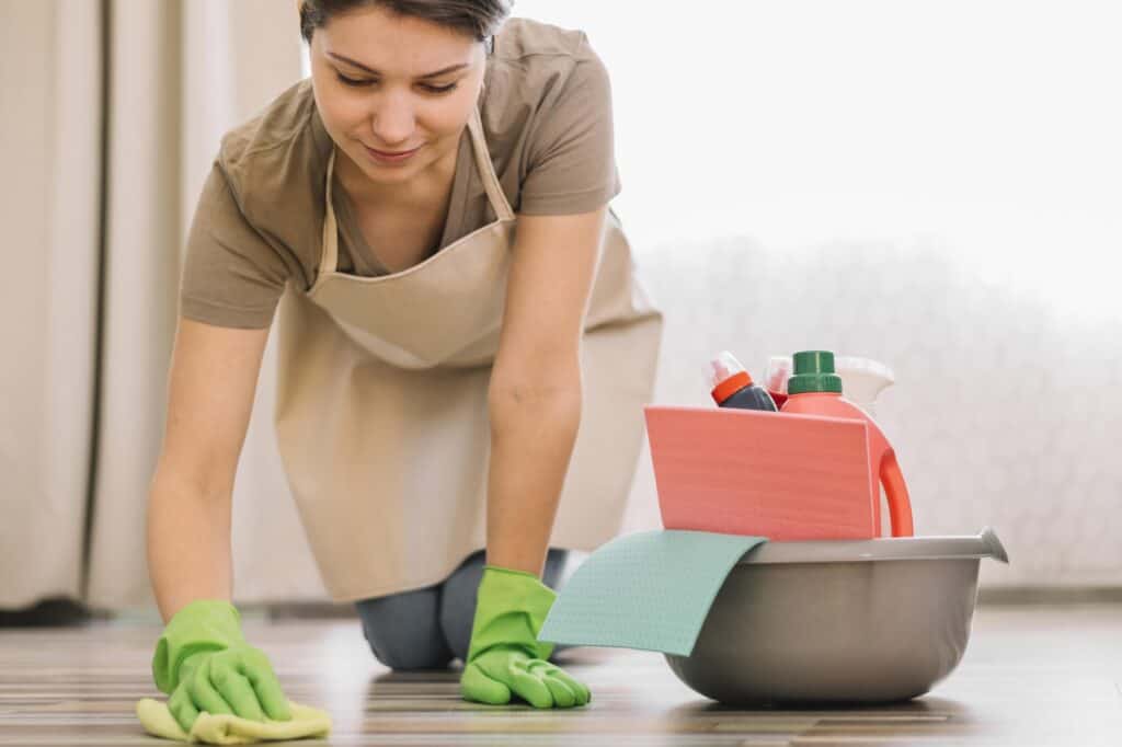 A woman wiping the floor of the new flat