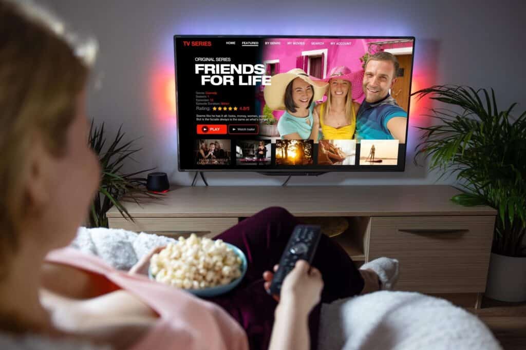 A woman watching on a streaming platform on a smart TV